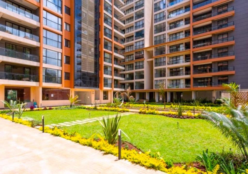an apartment building with a garden in front of it at Urban Haven 3BR Apartment in Nairobi