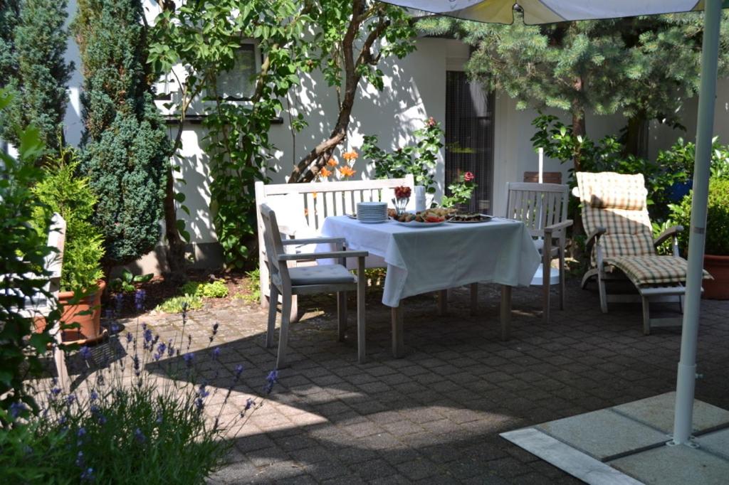 uma mesa e cadeiras num pátio debaixo de um guarda-sol em Weinhaus Steppe Hotel 3***Superior und Weinstube em Waldbronn