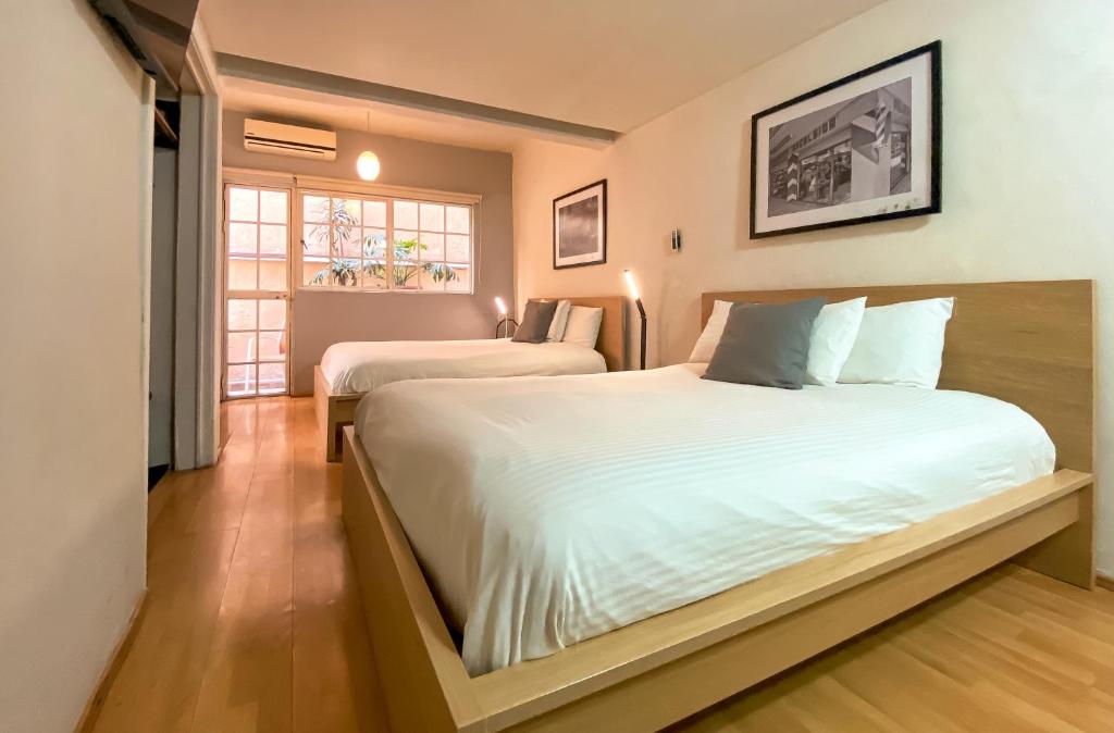 a bedroom with two beds and a window at Casa Condesa Amatlan 84 in Mexico City