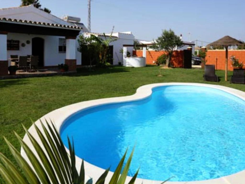 una gran piscina azul en un patio en Casa para Familias con piscina y Barbacoa, en Conil de la Frontera