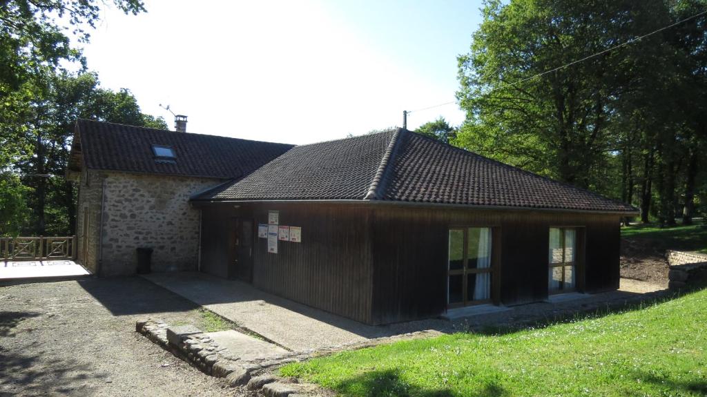 a small building in a yard next to a field at Gite 20 places in Razès