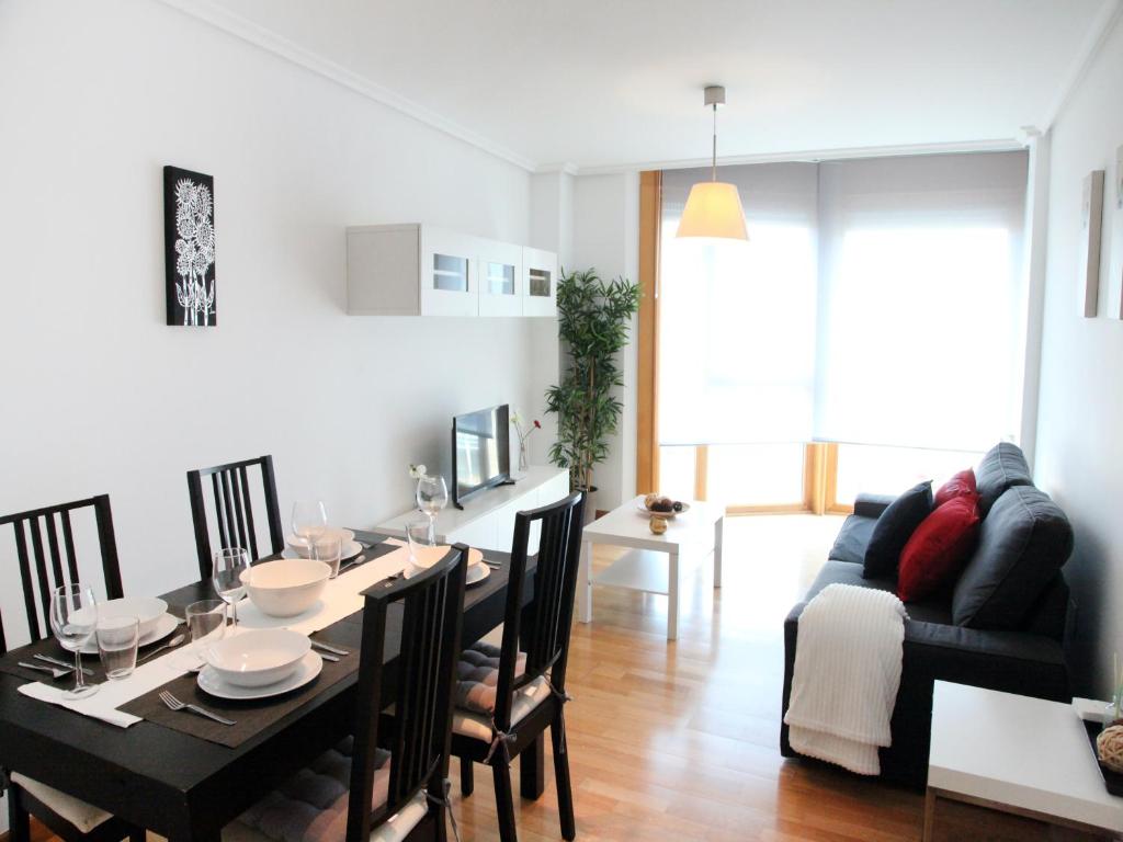 a dining room and living room with a table and chairs at Precioso apartamento en Santoña in Santoña
