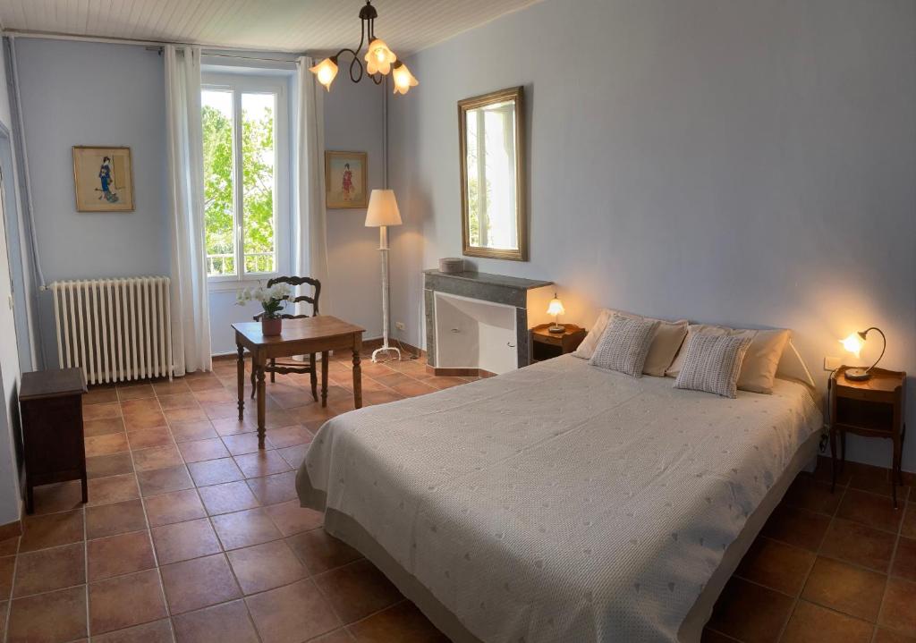 um quarto com uma cama, uma mesa e uma secretária em La Bastide de Villecroze em Villecroze