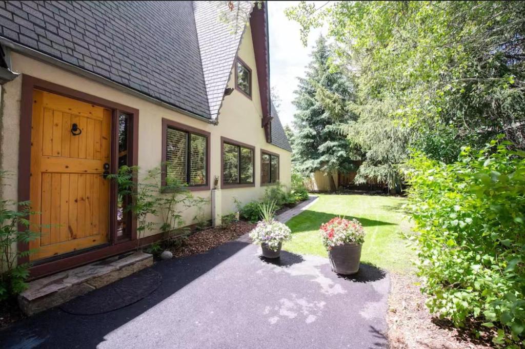 una casa con una puerta de madera y dos macetas en Ketchum Cottage en Ketchum