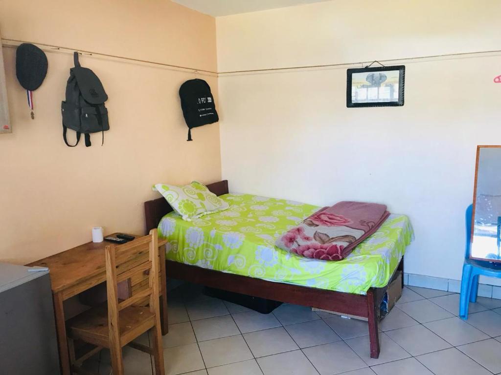 ein kleines Schlafzimmer mit einem Bett und einem Tisch in der Unterkunft lovely small home in Nairobi