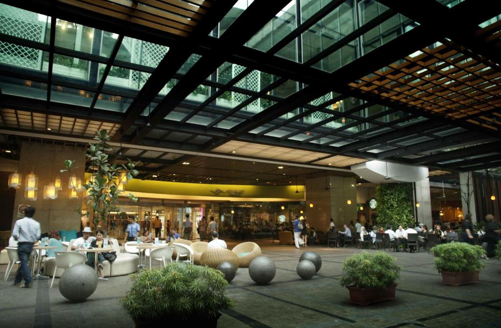 A covered public atrium provides café-style seating beneath a glass-and-steel roof.