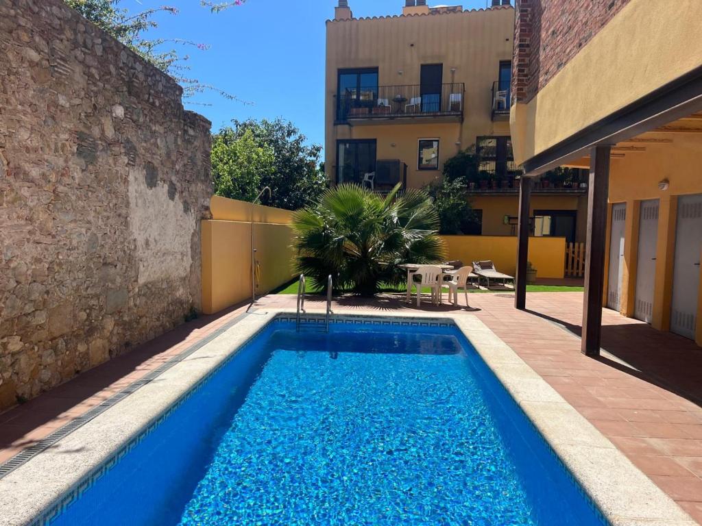 a swimming pool in a yard next to a building at Ground floor apartment in Centre of Torroella De Montgri in Torroella de Montgrí