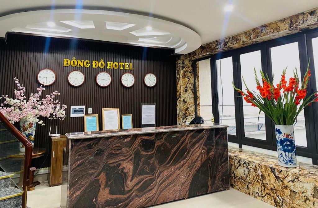 a lobby with clocks on the wall and flowers at Khách Sạn Đông Đô in Hai Phong