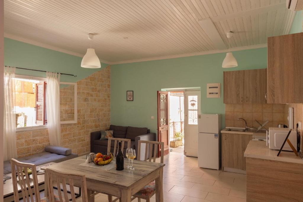 uma cozinha e uma sala de estar com uma mesa e uma cozinha em The Village Cottage - Benitses em Benitses