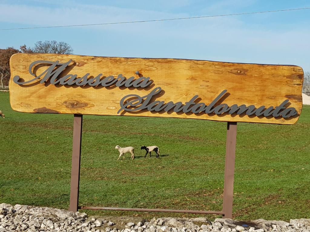 a sign with two sheep walking in a field at Masseria Santolomuto in Noci