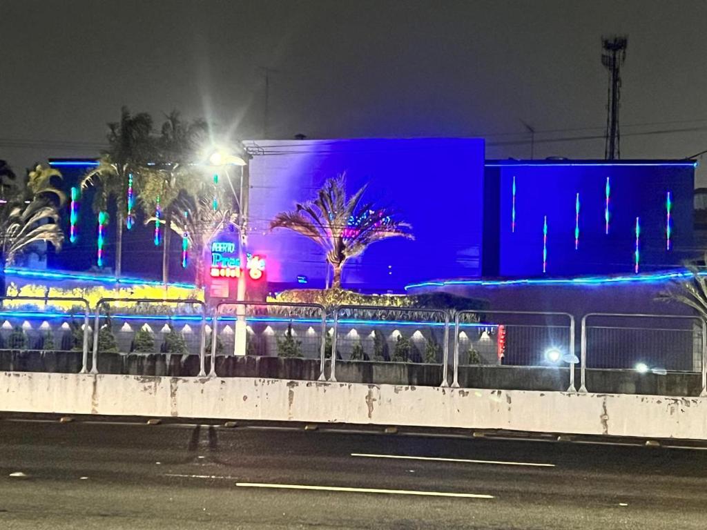 un edificio con luces azules en el lateral de una calle en Prestige Motel 2, en São Paulo