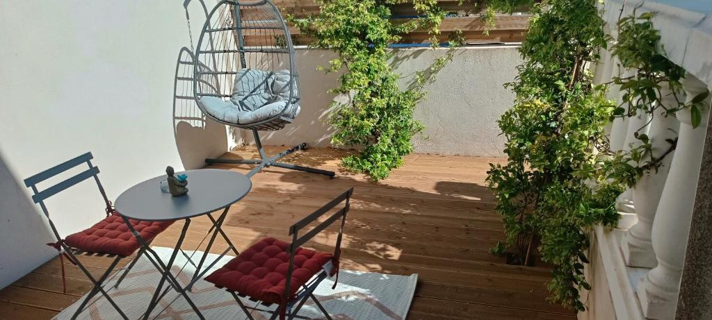 d'une terrasse avec une table, des chaises et des vignes. dans l'établissement Villa Semaphore, à Salin-de-Giraud