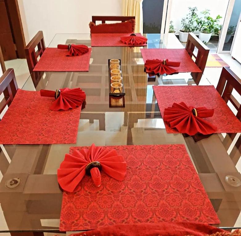 einen Tisch mit roten Servietten und roten Bögen darauf in der Unterkunft Pristine residence in Dehiwala