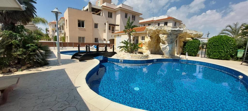 a swimming pool in front of a house at Pyla Palms Resort B1 204 in Pyla