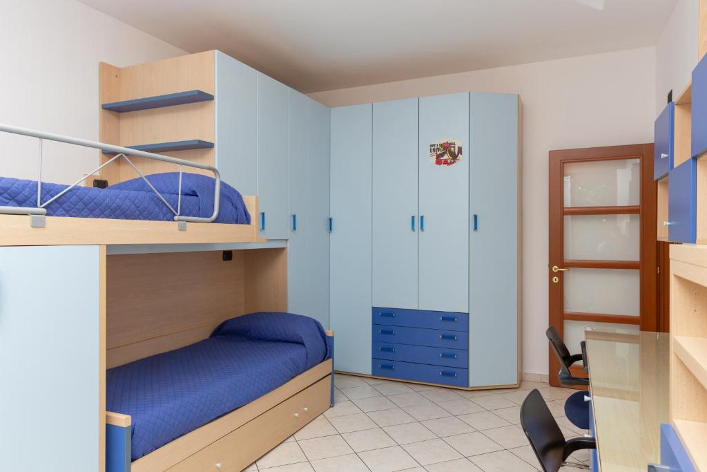 a bedroom with two bunk beds with blue sheets at Spacious Exclusive Apartment in Pioltello