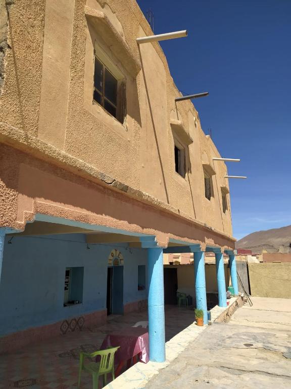 a building with blue columns in the desert at hotel atlas in Imilchil