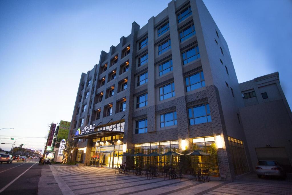 a large building on a city street at dusk at Sankaikan Hotel in Puzi