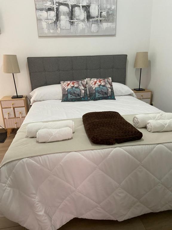 a large white bed with two towels on it at Calle Mayor in Alcalá de Henares