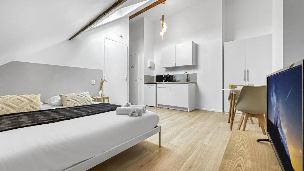 um quarto branco com uma cama e uma cozinha em Homey Cream - Joli Studio/Proche Vitam Parc em Viry