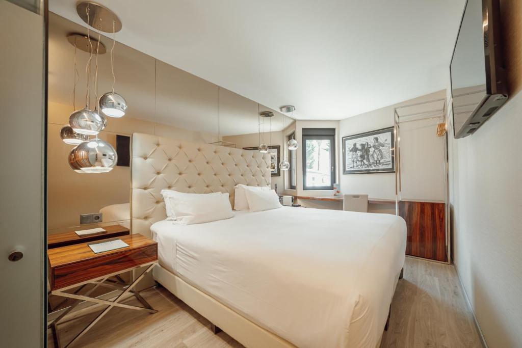 ABC Hotel Porto - Boavista في بورتو: غرفة نوم مع سرير أبيض كبير ومكتب