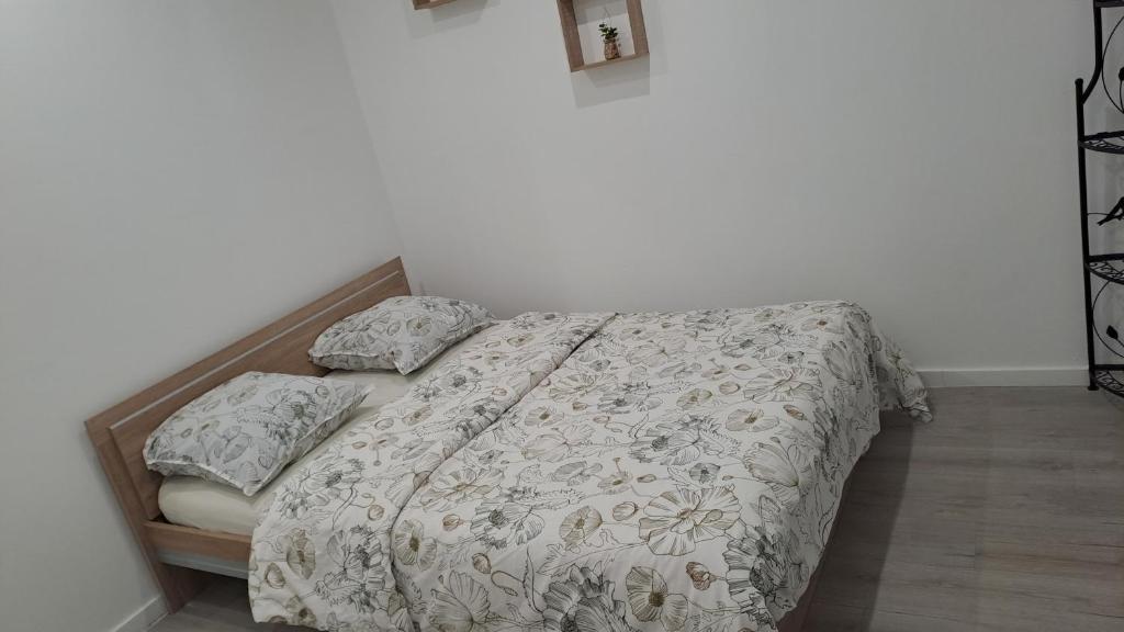 een slaapkamer met een bed met een sprei en kussens bij Appartement Arago in Roanne