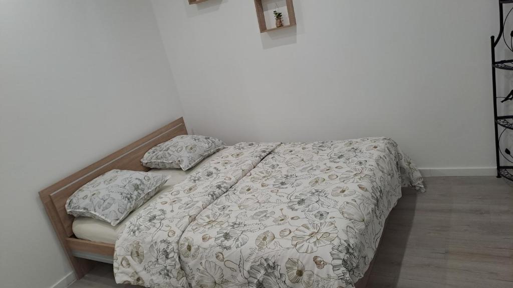 - une chambre avec un lit doté d'un couvre-lit et d'oreillers dans l'établissement Appartement Arago, à Roanne