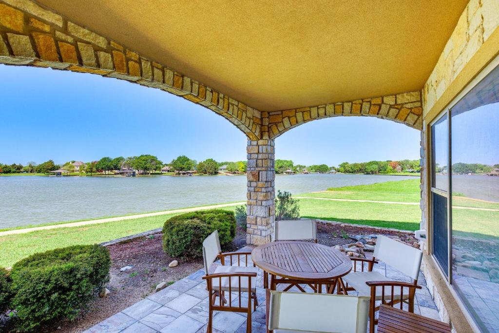 un patio con mesa y sillas y vistas al agua en Lakefront Corsicana Condo with Pool Access!, en Corsicana