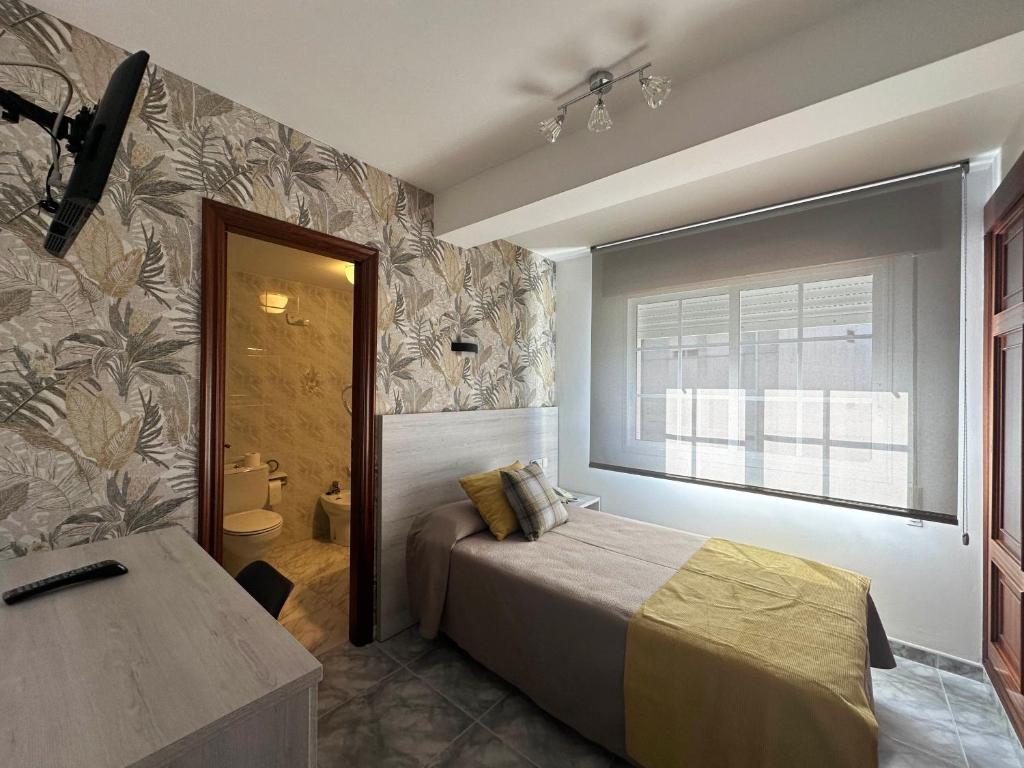 um quarto de hotel com uma cama e uma casa de banho em Hotel Florida Mar em Sanxenxo
