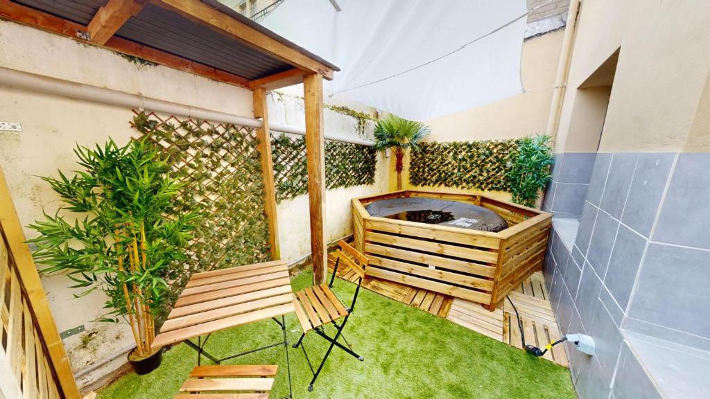 een terras met stoelen en een hek met planten bij Immeuble COTY Jacuzzi studios et chambres in Le Havre