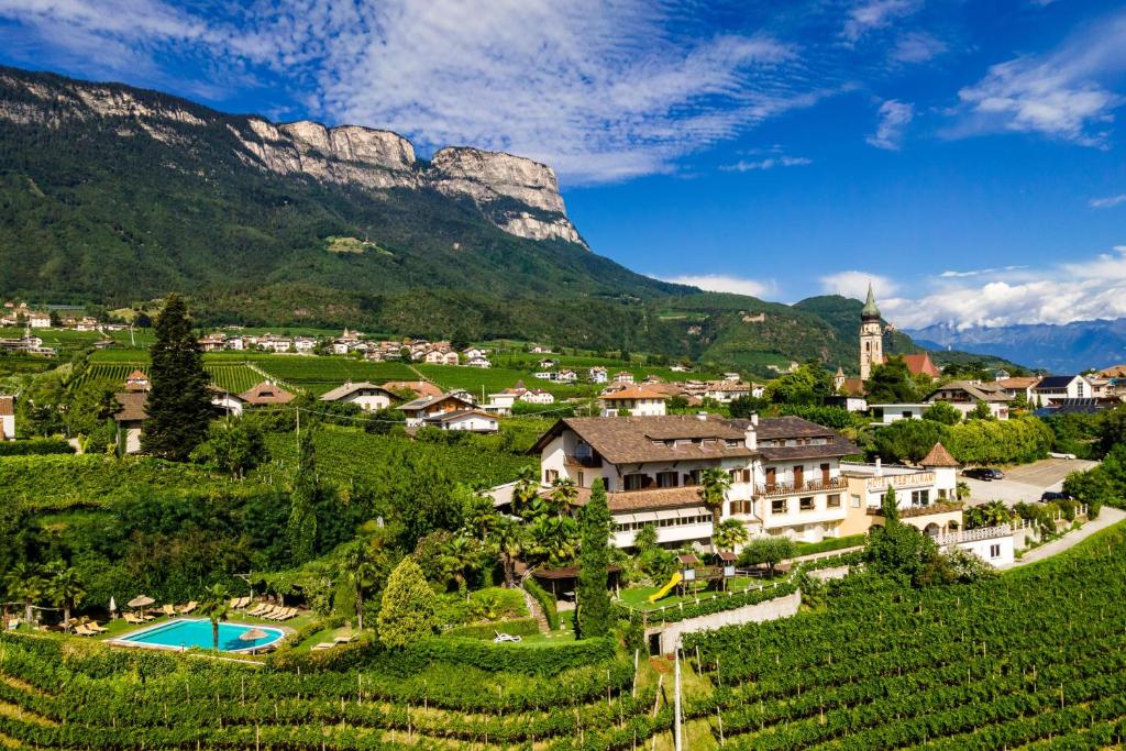 a village with a mountain in the background at Hotel Weinberg in Appiano sulla Strada del Vino