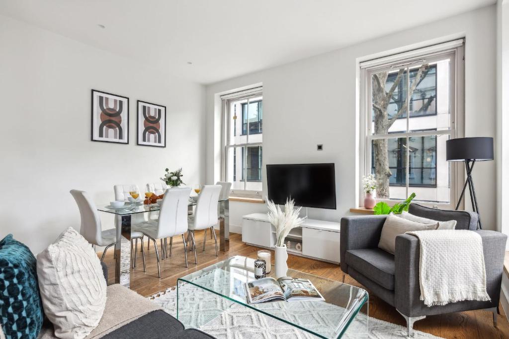 - un salon avec un canapé et une table dans l'établissement Fitzrovia 3BR - CityApartmentStay, à Londres