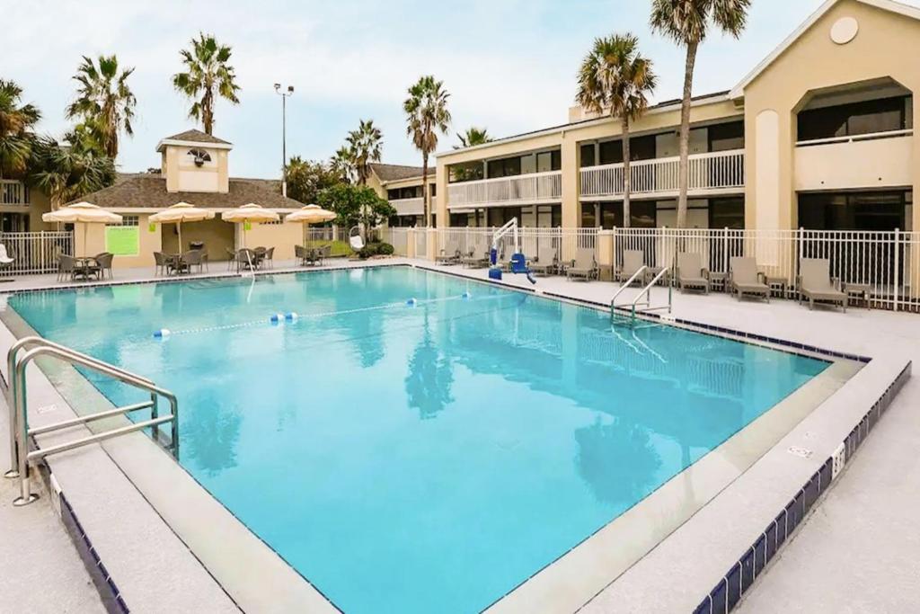 une grande piscine avec des palmiers dans l'établissement Upstay - Modern Suite w Pool - Mins From Disney, à Kissimmee