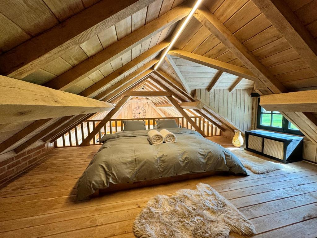 una camera da letto con letto in mansarda di Magnifique chalet en bois avec piscine et jacuzzi a Court-Saint-Étienne