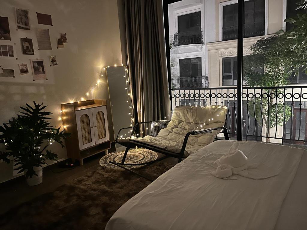 ein Schlafzimmer mit einem Bett, einem Stuhl und einem Fenster in der Unterkunft Ocean Park 2 - Superior room in Hòa Bình