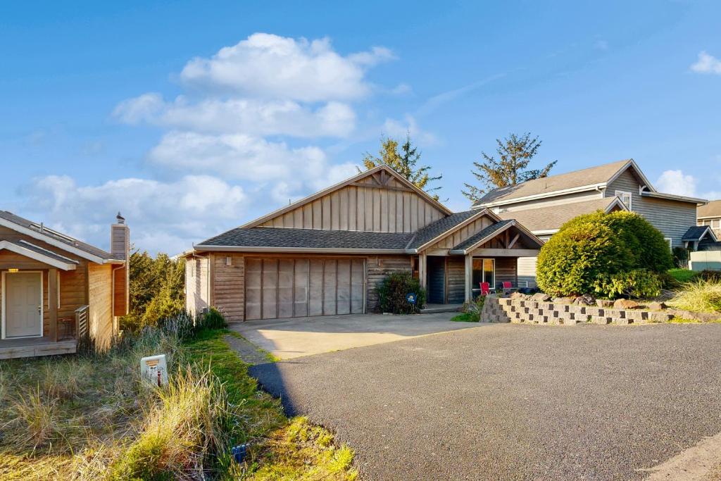 a house with a driveway in front of it at The Beach Arcade House in Pacific City