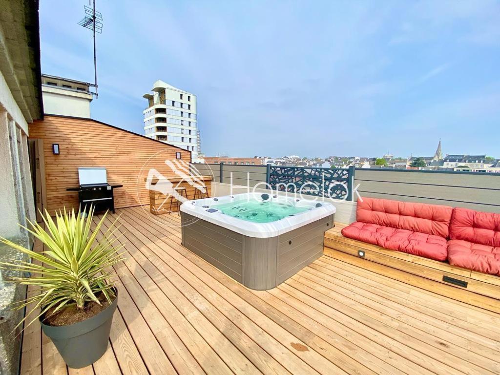 een terras met een hot tub en een bank op een balkon bij Exceptionnel ! T3 de standing - Rooftop - Jacuzzi in Lorient