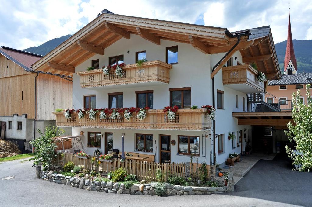 ein Gebäude mit einem Balkon mit Blumen darauf in der Unterkunft Talhammerhof in Uderns