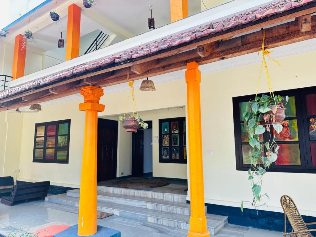 a house with orange columns and a porch at VEDHA AYURVEDIC in Alleppey
