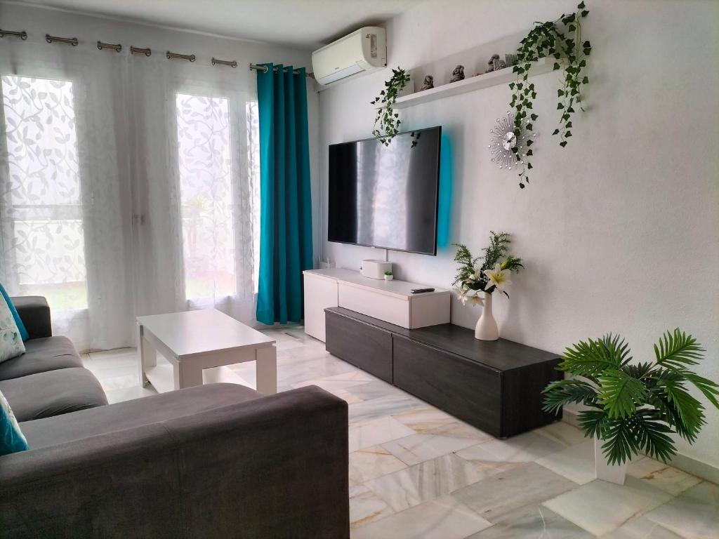 sala de estar con sofá y TV en Apartamento Las Abejeras, en Estepona