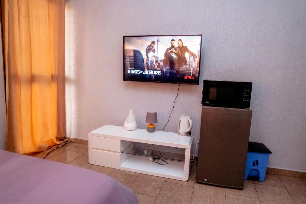 a bedroom with a flat screen tv on the wall at Studio cosy et agréable in Lomé