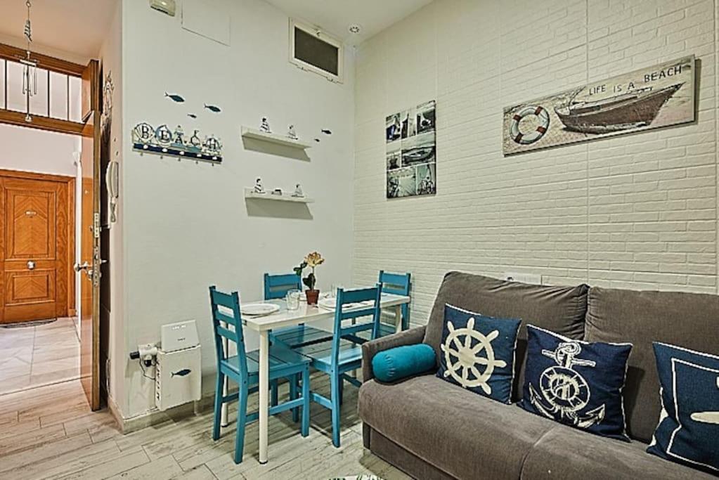 ein Wohnzimmer mit einem Sofa und einem Tisch mit Stühlen in der Unterkunft The Sailors House Ha in Cádiz