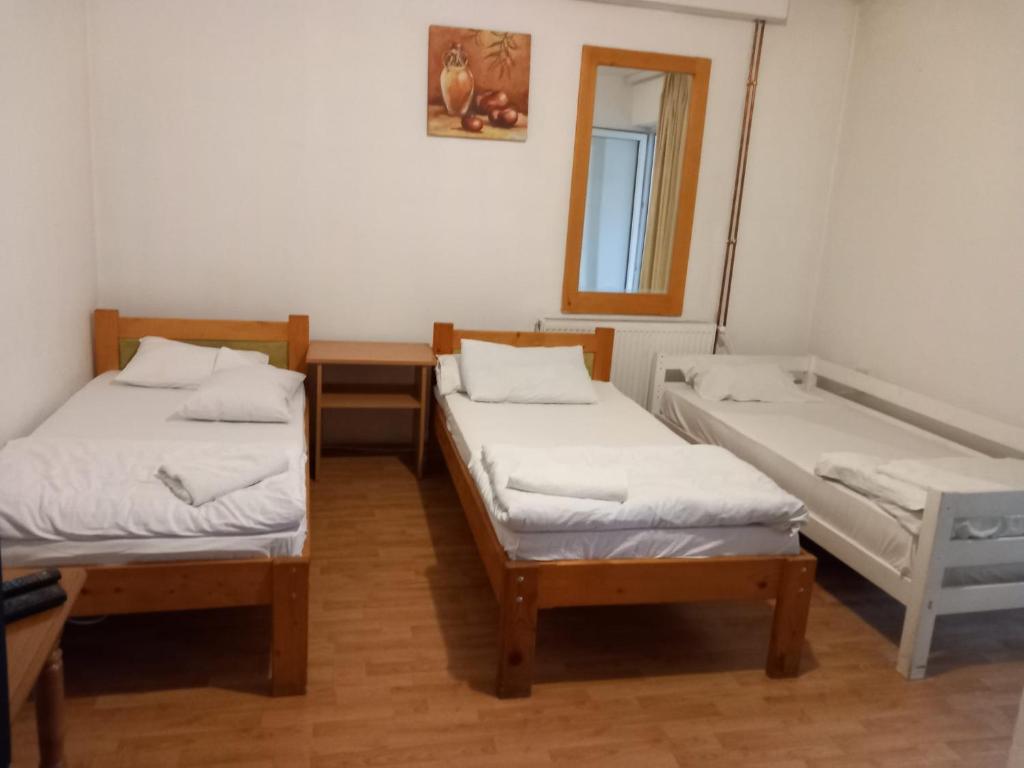 a room with two twin beds and a mirror at Hostel Wien in Novi Pazar