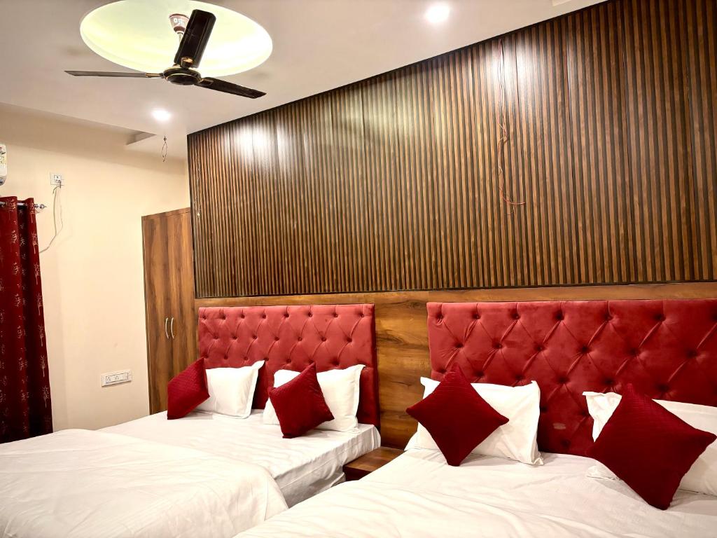 a hotel room with two beds with red headboards at HOTEL VIA GANGA INN ! VARANASI ! FULLY AIR-CONDITIONED HOTEL AT PRIME LOCATION WITH ROOFTOP GANGES VIEW! 2 Min walking distance from ASSI GHAT ,NEAR KASHI VISHWANATH TEMPLE in Varanasi
