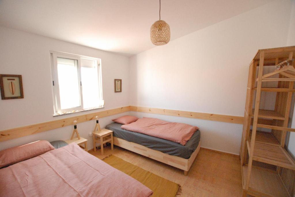 a bedroom with two beds and a window at Algarve Surf Hostel & Guest House in Raposeira