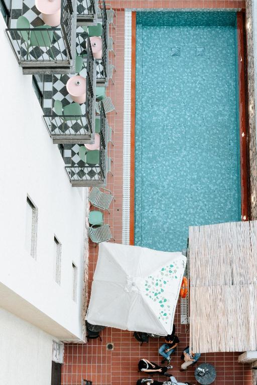 ein Regenschirm auf dem Boden neben einem Pool in der Unterkunft Hotel Shoshana - Adults Only in Eilat