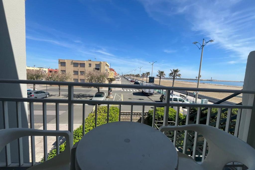 d'un balcon avec une table et une vue sur la plage. dans l'établissement Charming apartment overlooking the sea, à Port-la-Nouvelle
