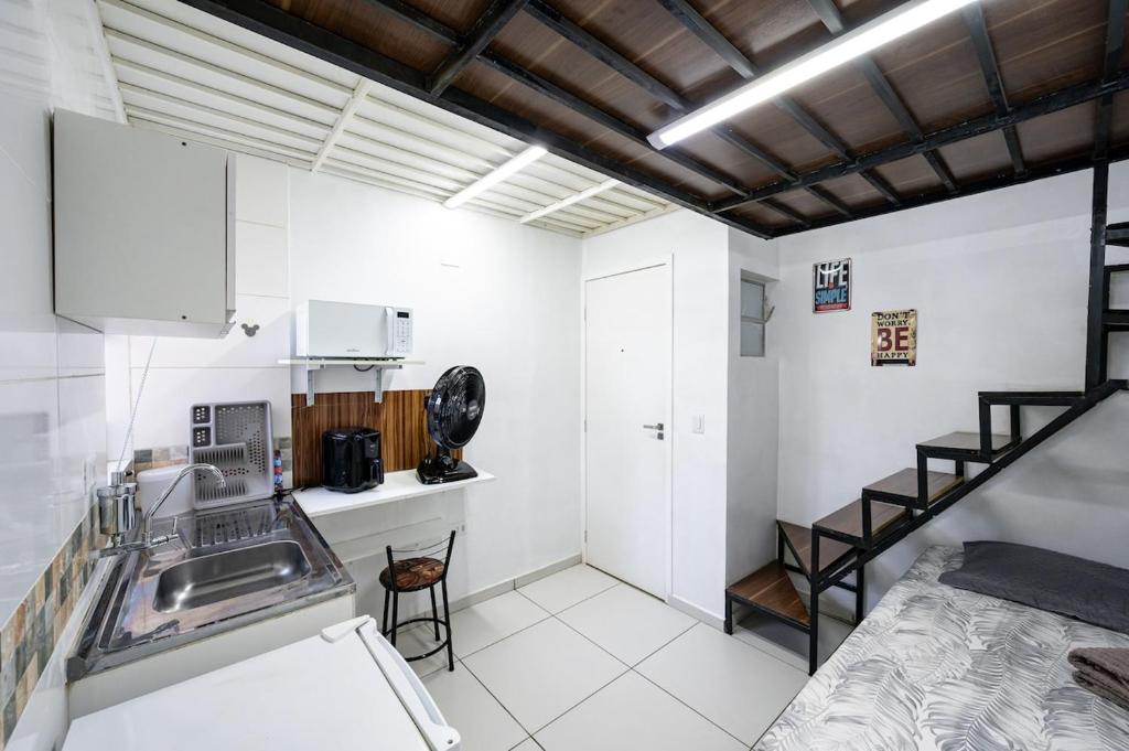 uma cozinha com um lavatório e uma escada num quarto em 46 LOFT TRIPLO · Mini apartamento em Metrô Jabaquara e EXPO em São Paulo