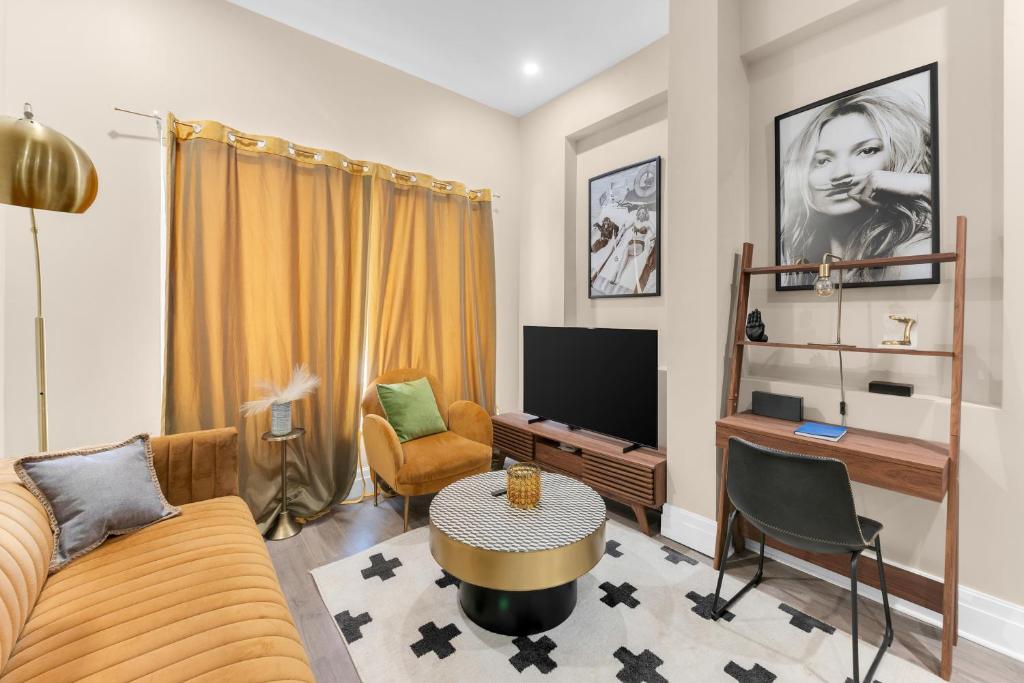 a living room with a couch and a tv at Charming 2BR Bkyrd Near Williamsburg in Brooklyn