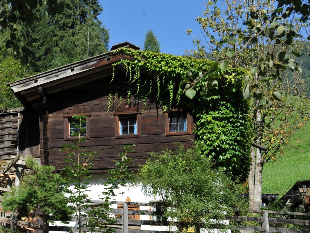 a wooden house with ivy on the side of it at Zinnhäusel in Alpbach
