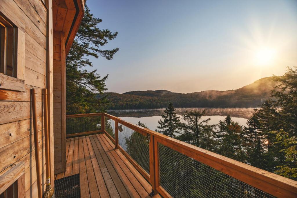 a deck with a view of a lake at Les Refuges Perchés Mont-Tremblant in Saint-Faustin